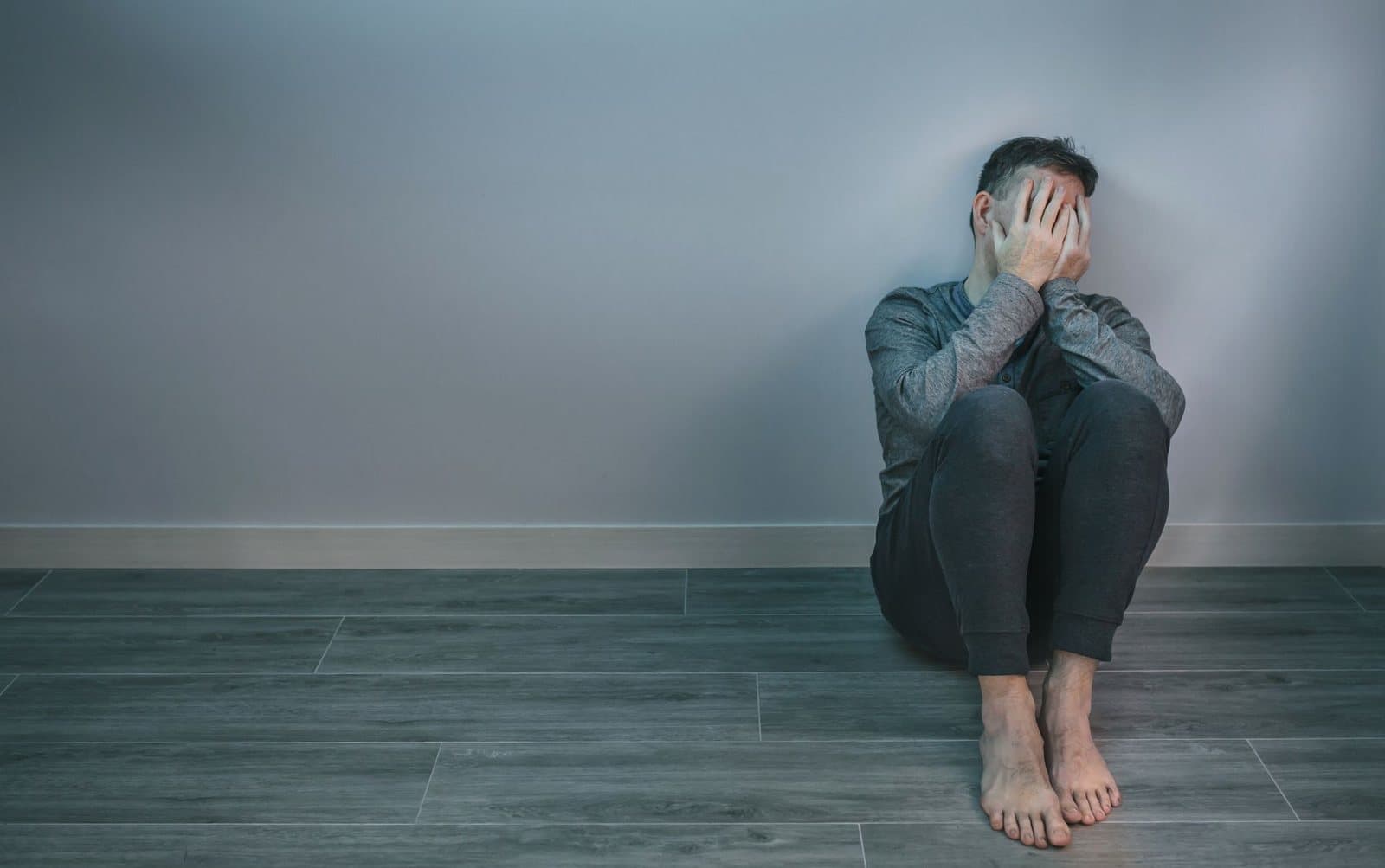 Person sitting on the floor with their head down