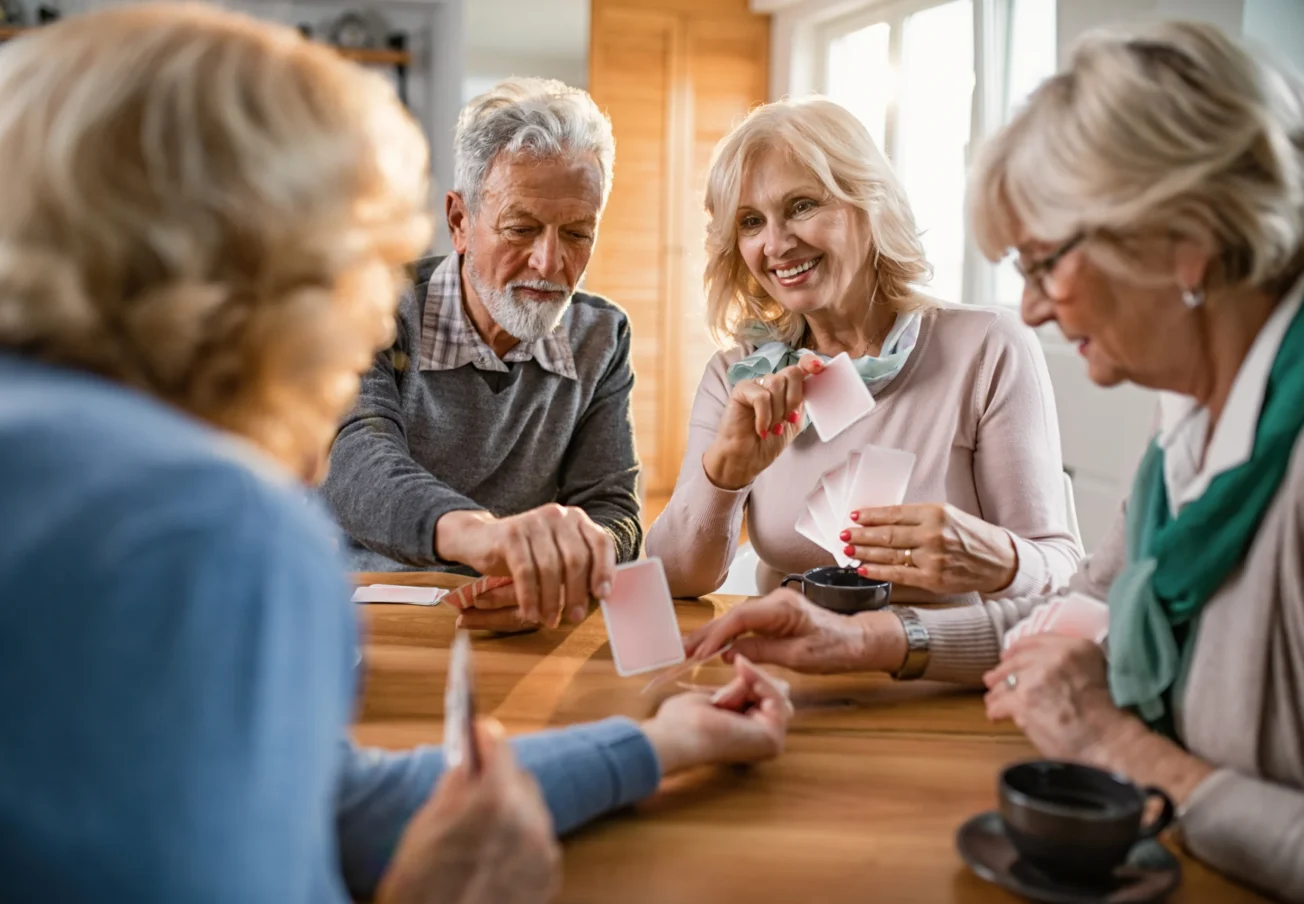 small-group-mature-friends-enjoying-while-playing-cards-home